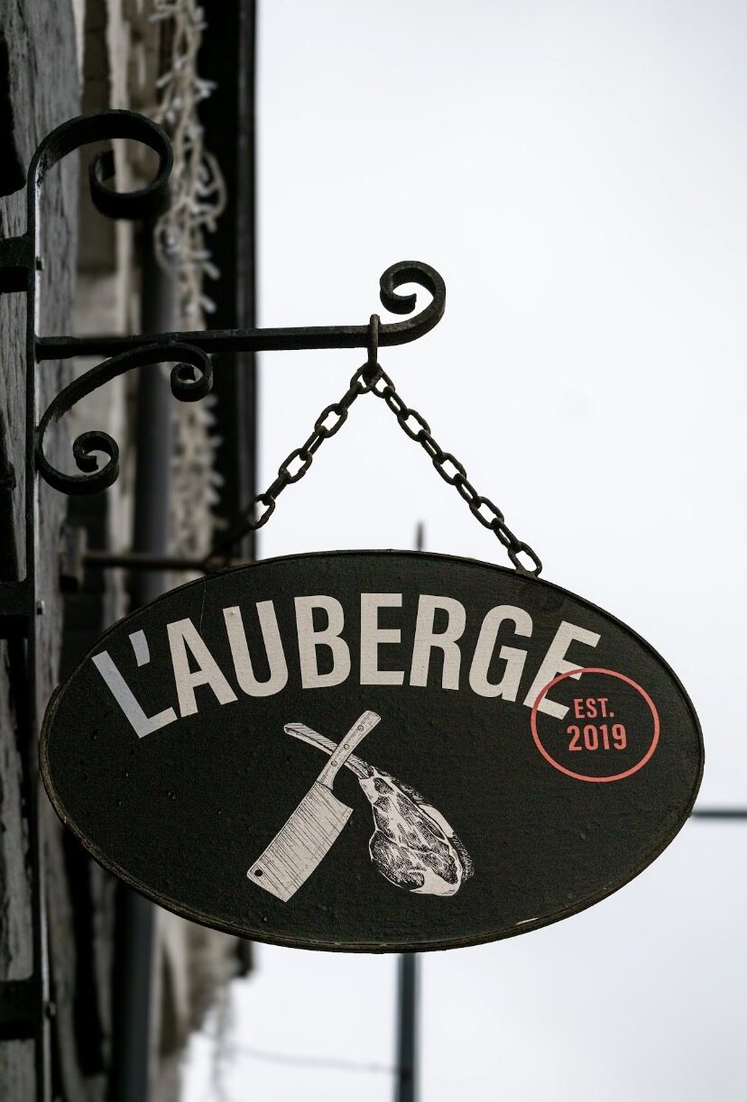 L'enseigne en fer forgé de L'Auberge de Mouvaux, avec le couperet et la côte de bœuf, Est. 2019