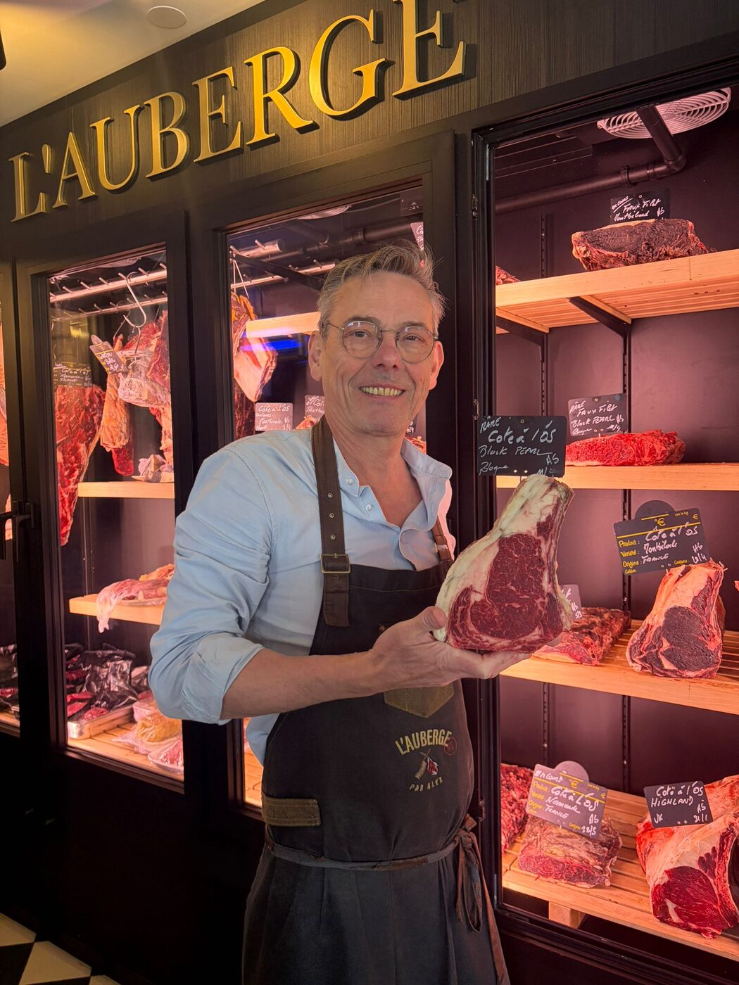 Philippe, le boucher de L'Auberge de Mouvaux, avec une côte de bœuf devant la cave de maturation